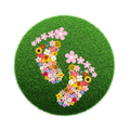 Eine kreisförmige grüne Grasfläche mit einer Blumenanordnung in Herzform und einem Globus in der Mitte.