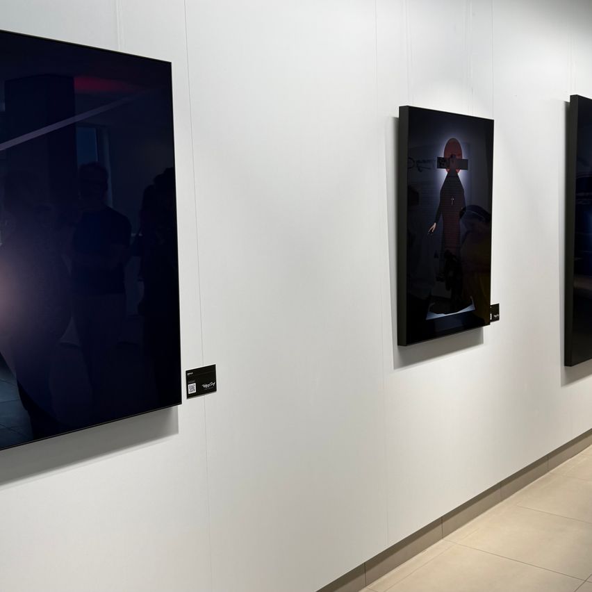 Drei gerahmte digitale Kunstwerke sind an einer weißen Wand aufgehängt. Das linke Stück ist schwarz, während das mittlere ein Halo um eine Person zeigt und das rechte dunkel ist.