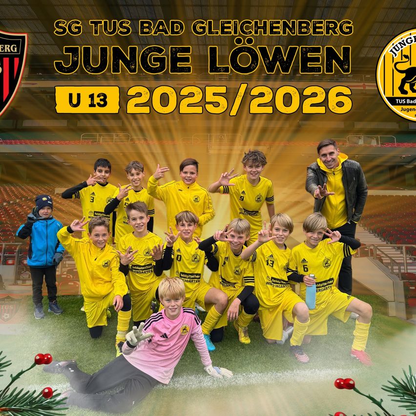 Eine Fußballmannschaft junger Jungen in gelben Trikots mit Nummern, die in einem Stadion mit roten Sitzen für ein Foto mit einem Trainer posiert.