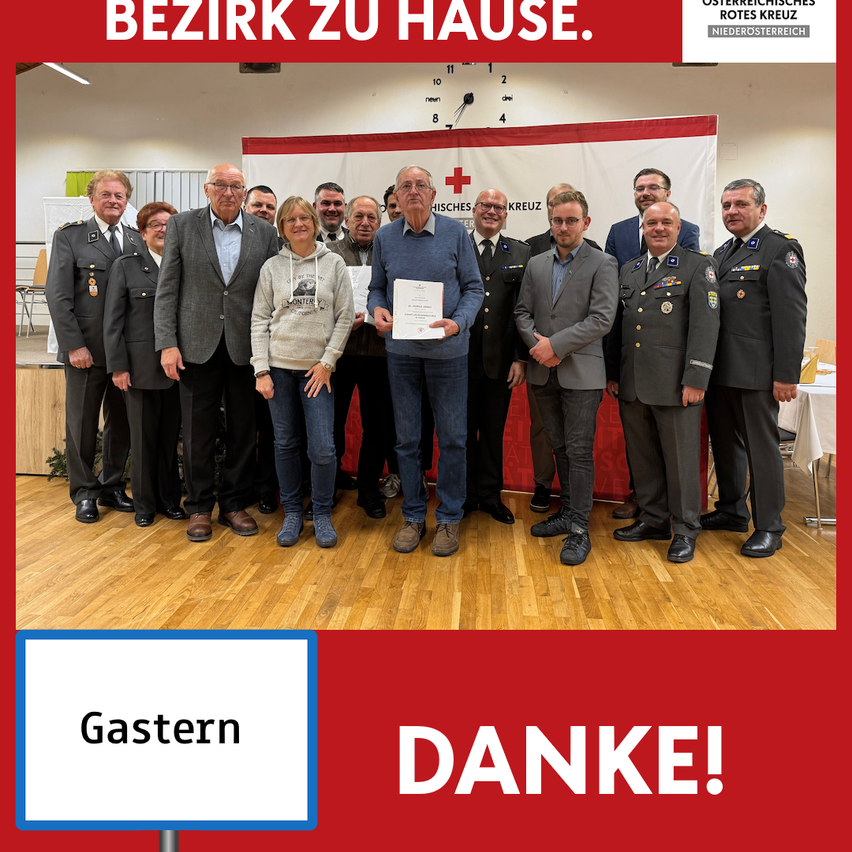 Gruppenfoto von Menschen, die stehen und einer, der ein Zertifikat hält. Das Bild zeigt 'Gastern Danke!' mit einem Banner dahinter.