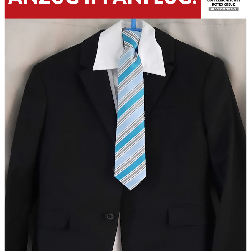 Ein schwarzer Anzug mit weißem Kragen und blau gestreifter Krawatte hängt an einem Kleiderbügel. Der Anzug hat zwei Knöpfe auf der linken Seite und eine Tasche auf der rechten. Das Bild hat einen Wasserzeichen in der oberen linken Ecke.