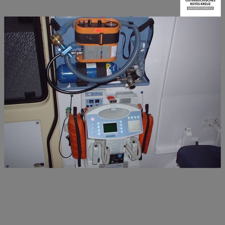 Ein Krankenwagen mit medizinischer Ausrüstung im Inneren, einschließlich eines Beatmungsgeräts, eines Sauerstofftanks und verschiedener medizinischer Geräte, die an der Wand montiert sind.