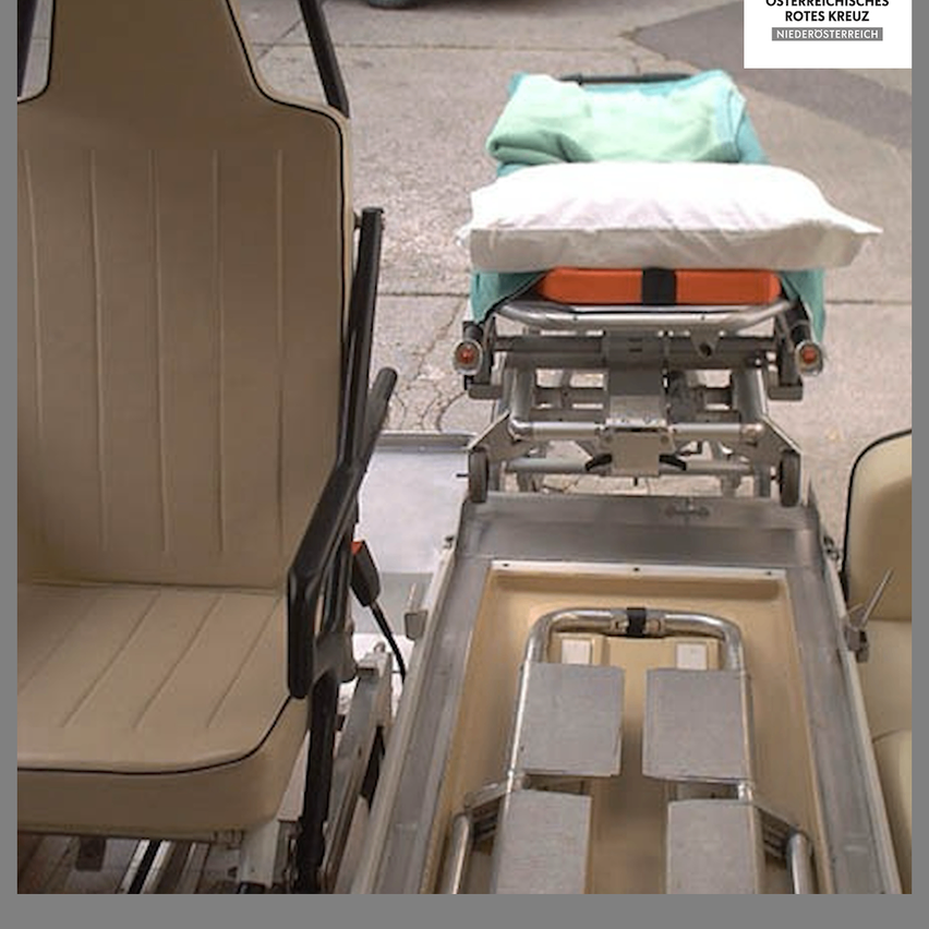 Ein Krankenwagen mit einer Trage und medizinischer Ausrüstung steht am Straßenrand bereit.