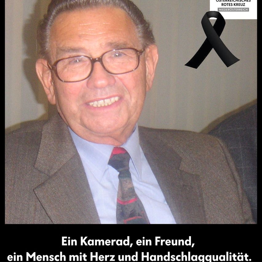 Ein Mann mit Brille und Anzug lächelt. Ein schwarzer Trauerflor ist in der oberen rechten Ecke. Unten steht deutscher Text.