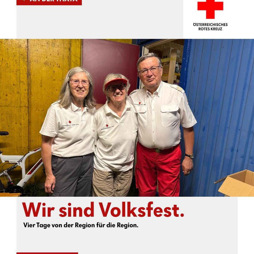 Drei Personen in weißen Uniformen und roten Hosen posieren für ein Foto vor einer blauen Wand. Der Mann trägt eine Brille, einen Gürtel und eine Uhr. Die Frau trägt eine Mütze und eine Brille.