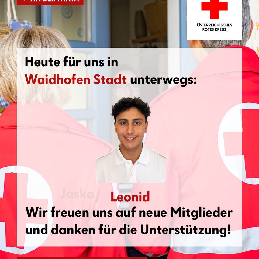 A smiling man, Leonid, stands in front of a group of people wearing red jackets with a red cross emblem, indicating a recruitment event for the Austrian Red Cross in Waidhofen.
