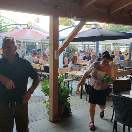 Bild enthält, Potted Plant, Shelter, Shorts, Portrait, Dining Table, Table, Restaurant, Dining Room, Street, Sandal