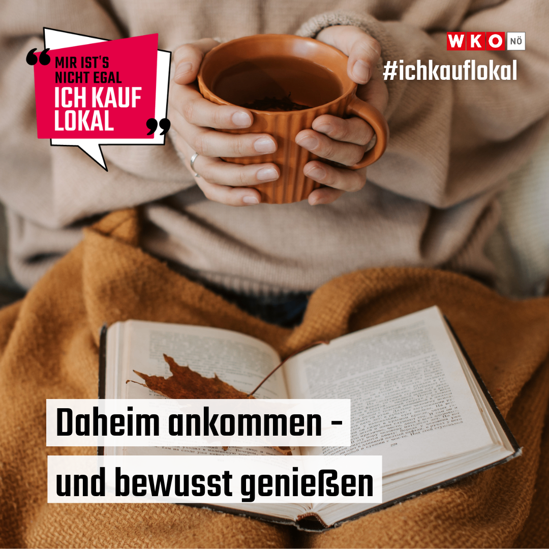 A person wrapped in a blanket, sitting and holding a cup of tea, with an open book on their lap. The book reads, 'Come home and enjoy consciously'. A speech bubble reads, 'For me, it doesn't matter, I buy locally'.