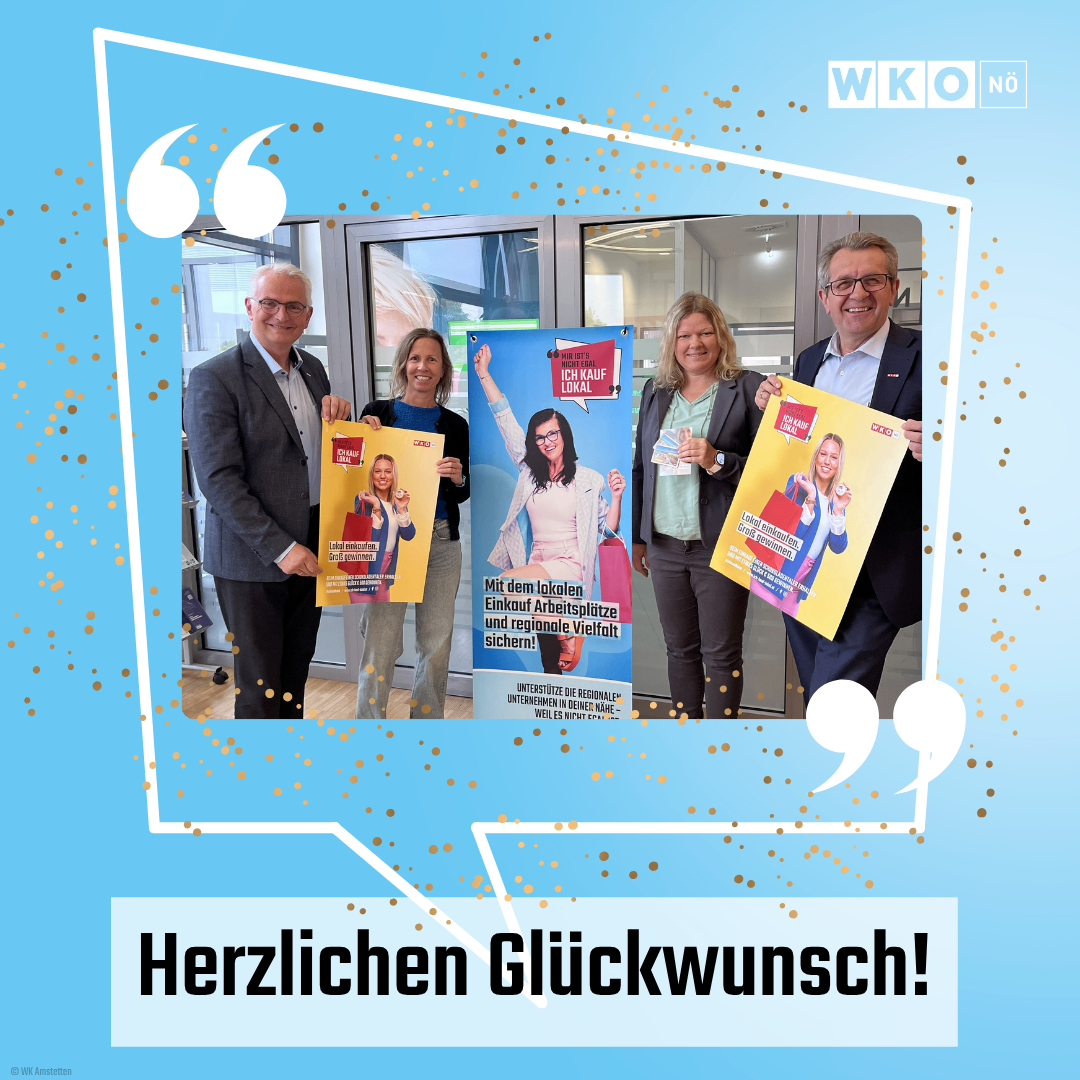 Eine Gruppe Erwachsener hält Poster vor einem Geschäft und lächelt für ein Foto. Die Poster lesen 'Ich kauf lokal' und zeigen eine Frau. Darunter steht 'Herzlichen Glückwunsch!'