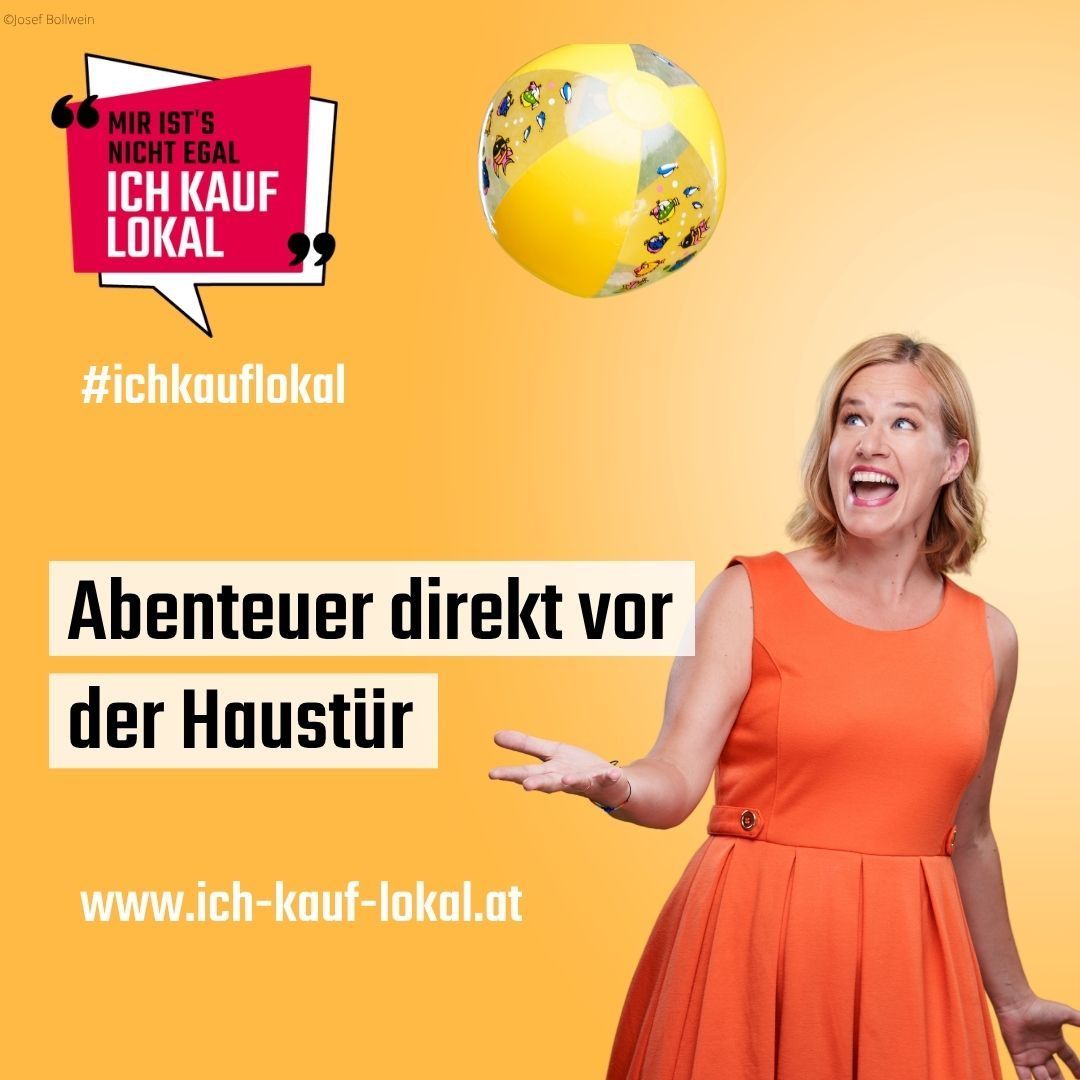 Eine Frau in einem orangefarbenen Kleid streckt ihre Hand in Richtung eines gelben Balls. Im Hintergrund steht 'Abenteuer direkt vor der Haustür' und es wird eine Website angezeigt. Ein Sprechblase sagt, 'MIR IST'S NICHT EGAL, ICH KAUF LOKA'.