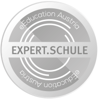 Silbernes kreisförmiges Logo für EXPERT.SCHULE, mit stilisiertem 'E' und 'S' und Wellenmuster. Der Text 'eEducation Austria' befindet sich im oberen Halbkreis.