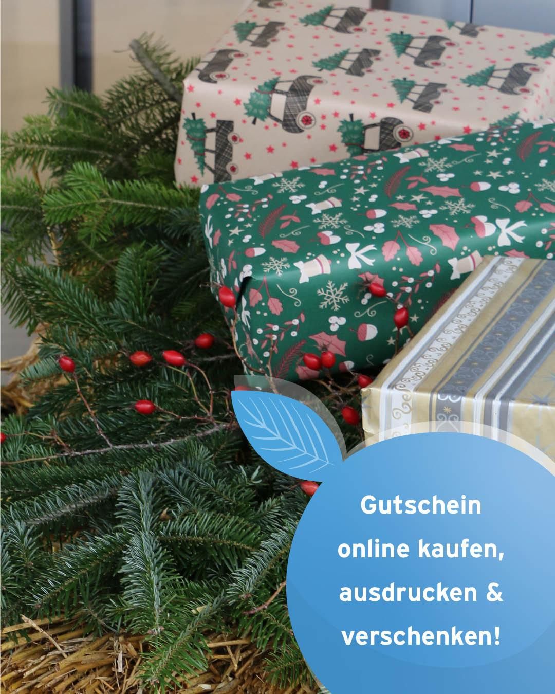Gewickelte Geschenke mit Weihnachtsmustern stehen zwischen Zweigen mit roten Beeren. Ein Banner im Vordergrund lautet: 'Gutschein online kaufen, ausdrucken &.'