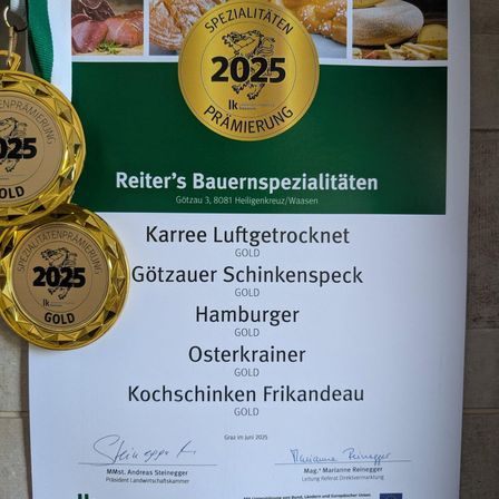 Ein Poster mit Goldmedaillen, Bilder von Lebensmitteln und einem Zertifikat. Reiter's Bauernspezialitäten ist in Gold geschrieben, zusammen mit anderen Namen und Artikeln. Das Poster enthält auch eine Unterschrift.