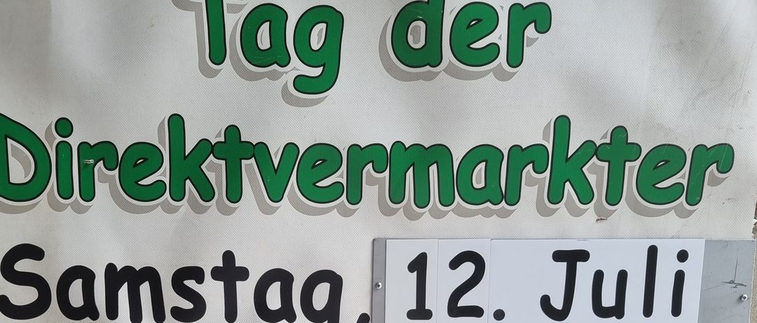Plakat für einen Direktmarkt am Samstag, 12. Juli, von 9 Uhr bis 13 Uhr. Familie Menitz in der Eisenstädter Straße 18, 2485 Wamping. Es zeigt verschiedene Produkte wie Fleisch, Würste, Marmeladen und Weine.