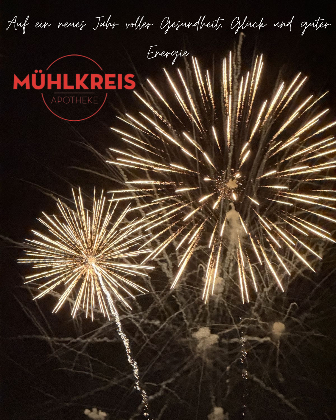 Zwei Feuerwerke explodieren in der Nacht, eines mit einem roten Kreislogo, das 'Mühlkreis Apotheke' liest. Das Feuerwerk zeigt leuchtende goldene Farben vor dem dunklen Hintergrund.