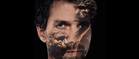 Ein Mann mit schwarzem Hemd hat ein schädelartiges Gesicht auf seinem Gesicht und Hals gemalt. Die Malerei hat eine orange und goldene Farbe. Der Mann hat einen ernsten Ausdruck.