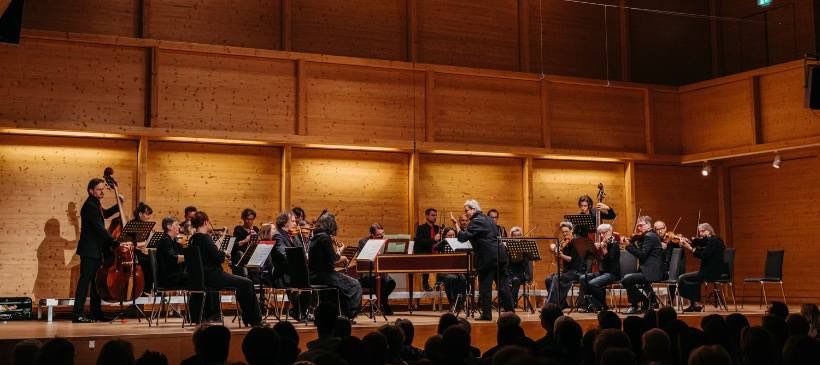 Bild enthält, Indoors, Group Performance, Person, Concert, Music, Musical Instrument, Musician, Orchestra, Performer, Mace Club