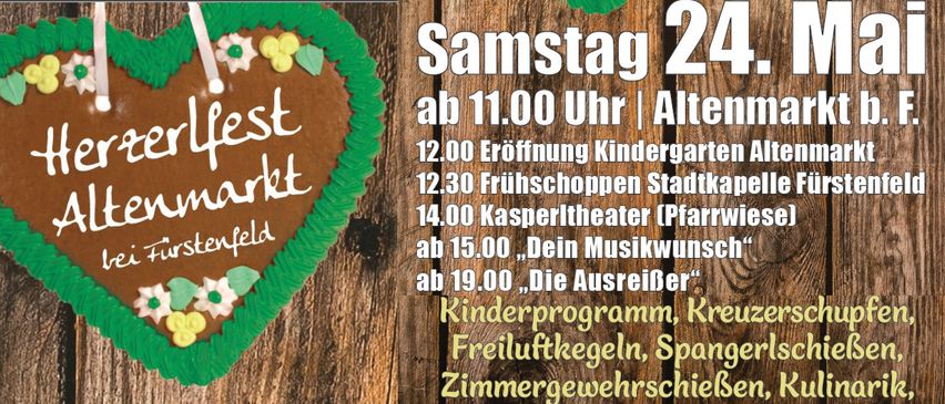 Ein Poster mit hölzerne Hintergrund und Text auf Deutsch. Ein herzförmiger Lebkuchen mit grüner Glasur und gelben Dekorationen ist auf der linken Seite.