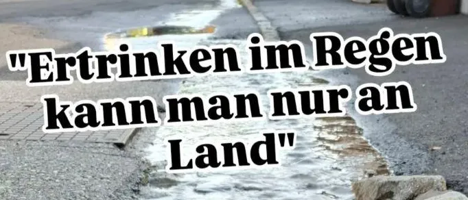 Ein Bild zeigt einen überfluteten Abfluss auf einer Straße mit einer Beschriftung auf Deutsch. Die Beschriftung lautet 'Ertrinken im Regen kann man nur an Land'. Darunter befinden sich Datum und Ort: 25. September, Museum Pfeilburg, 18:30 Fürstenfeld.