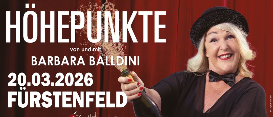 Ein Poster zeigt eine Frau, die eine Flasche Champagner hält und sie öffnet. Oben steht 'EPUNKTE'. Die Frau trägt einen Hut und der Hintergrund ist rot.