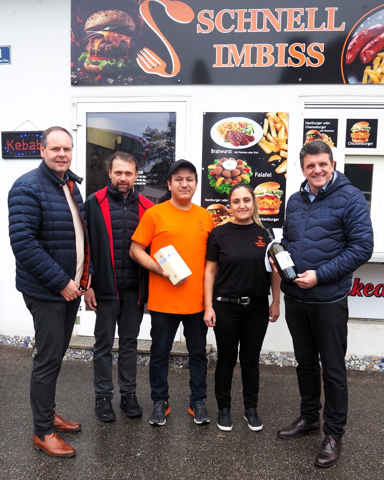 Bild enthält, People, Person, Pants, Burger, Coat, Jacket, Advertisement, Poster, Groupshot, Shoe