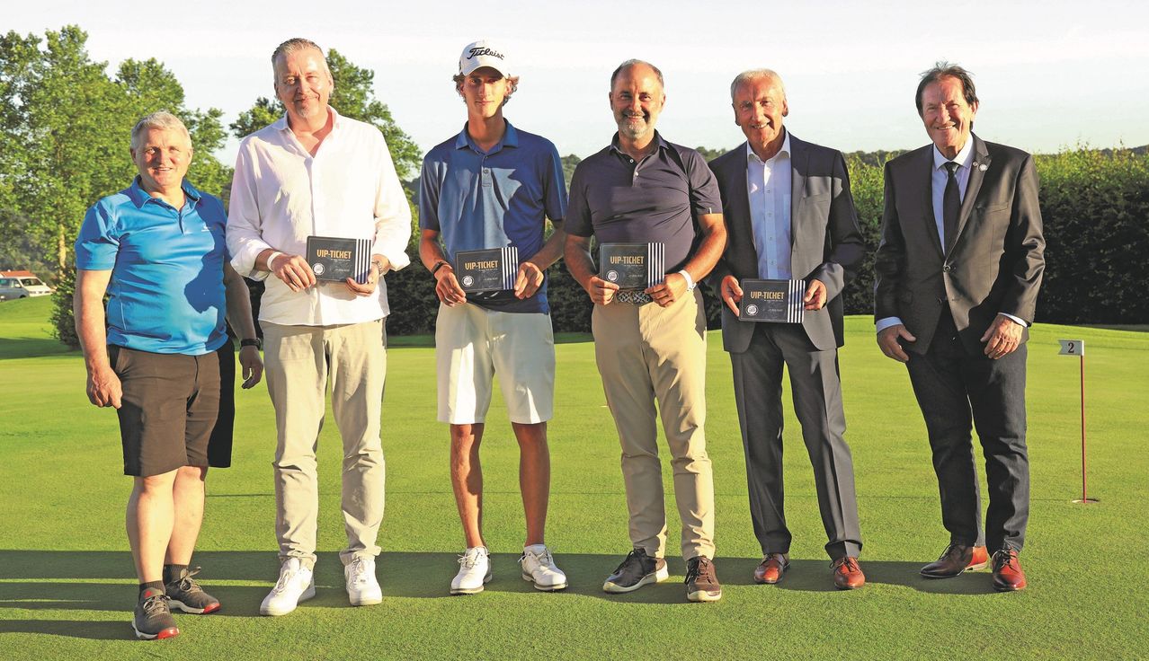 Vier Männer stehen auf einem Golfplatz, lächeln und halten VIP-Tickets. Der Mann in der Mitte trägt eine weiße Mütze und ein blaues Poloshirt. Die anderen tragen formelle Kleidung.