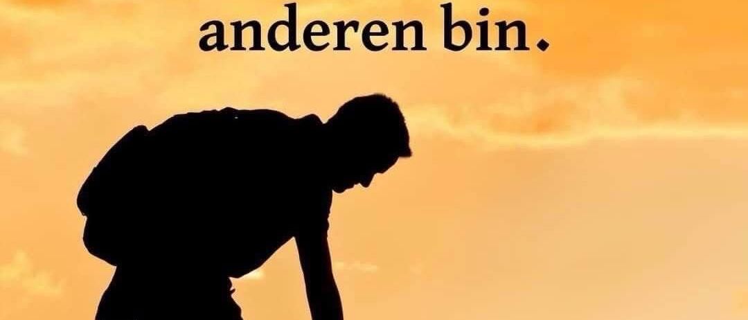 Schirmbild eines Mannes mit Rucksack, der einer anderen Person gegen einen Sonnenuntergangshintergrund hilft. Der Text lautet: 'Warum helfen dir andere nicht? Weil ich nicht wie die anderen bin.'