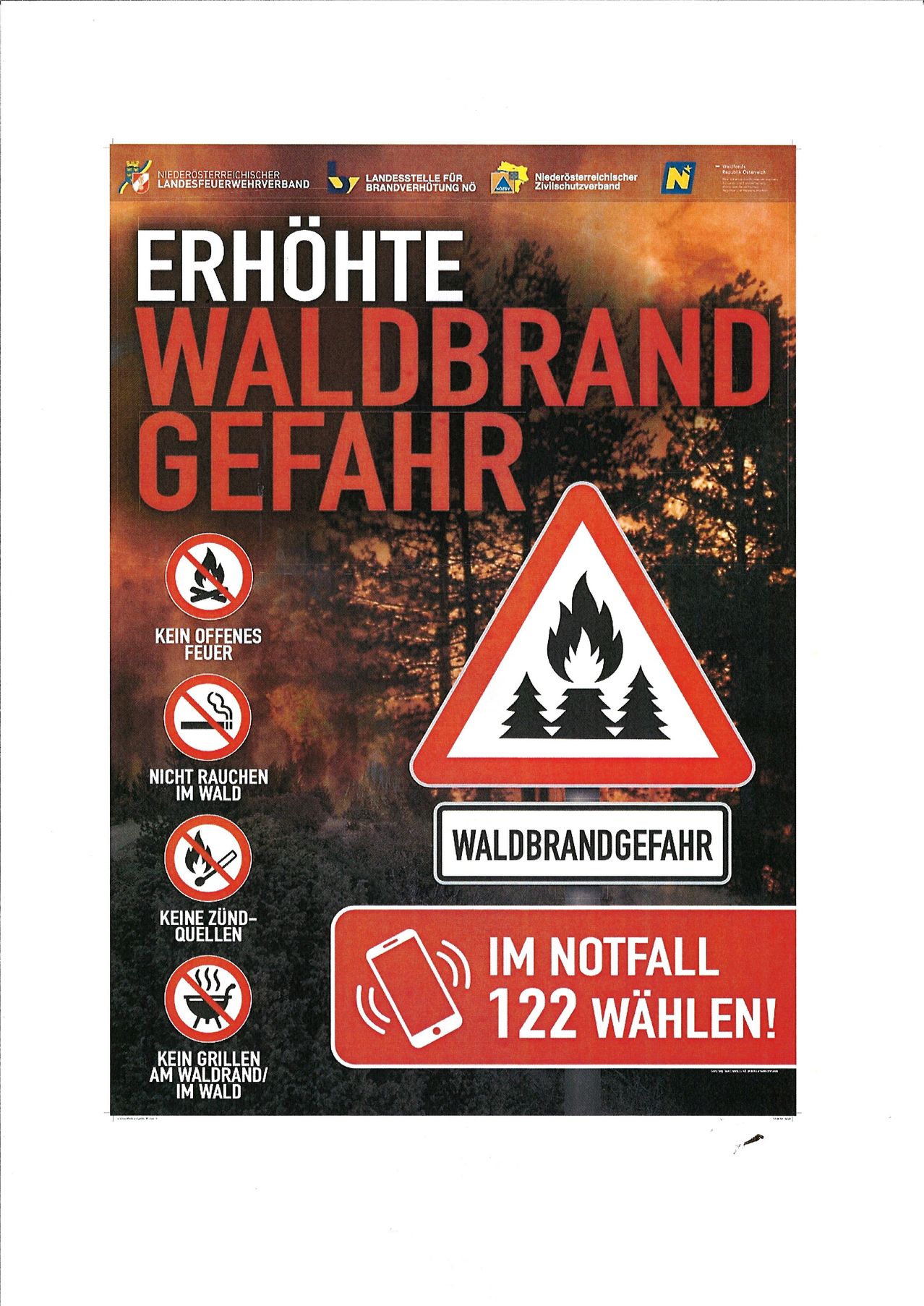 Ein Plakat mit einer Warnung vor erhöhter Waldbrandgefahr. Es zeigt ein Feuerzeichen, Rauchverbot und offenes Feuer Verbotszeichen sowie ein Telefonsymbol mit der Notrufnummer 122.