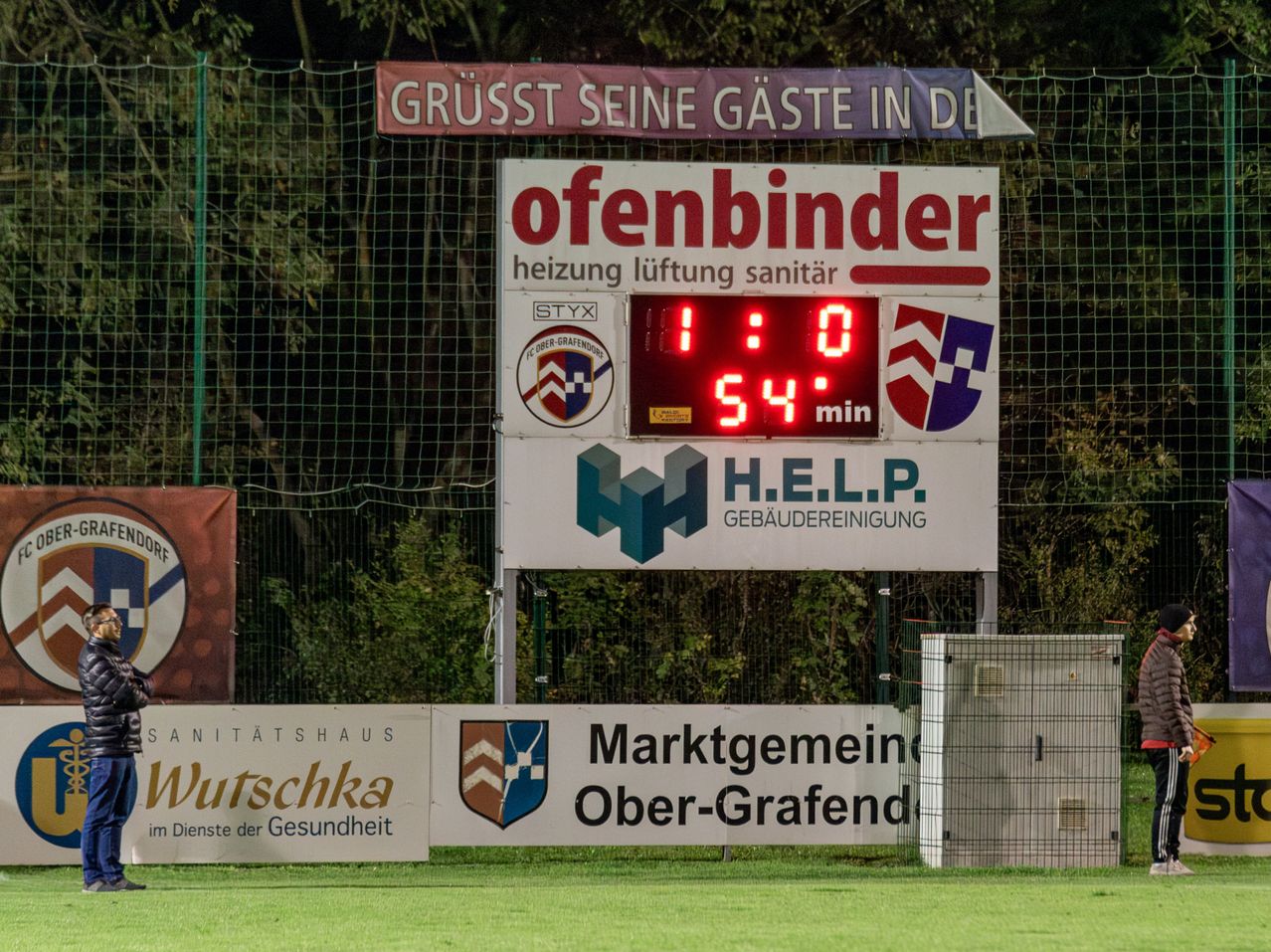 Bild enthält, Computer Hardware, Electronics, Hardware, Monitor, Screen, Person, Scoreboard, People