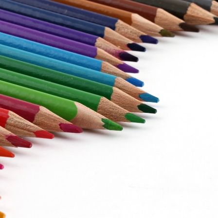 Ein Nahaufnahme einer Reihe von Buntstiften in verschiedenen Farben auf weißem Hintergrund.