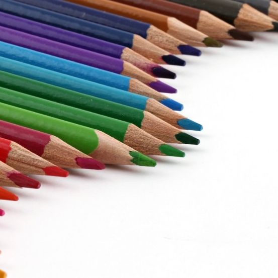 Ein Nahaufnahme einer Reihe von Buntstiften in verschiedenen Farben auf weißem Hintergrund.