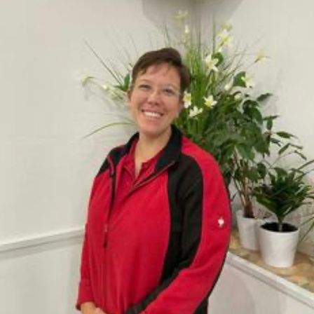 Bild enthält, Potted Plant, Coat, Jacket, Face, Head, Person, Smile, Flower Arrangement, Portrait, Ikebana