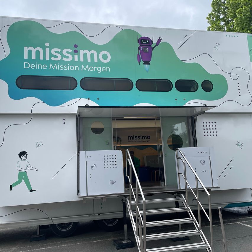 Ein weißer Anhänger mit dem Wort missimo an der Seite, einer Illustration eines Roboters und eines laufenden Mannes, einer offenen Tür und einer Metalltreppe, die hinaufführt.
