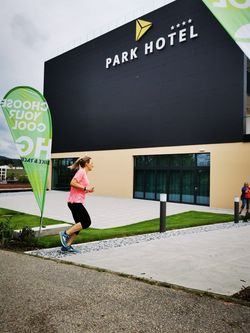 Person, Walking, Building, Office Building, Shopping Mall, Advertisement, Outdoors, City, Grass, Blackboard