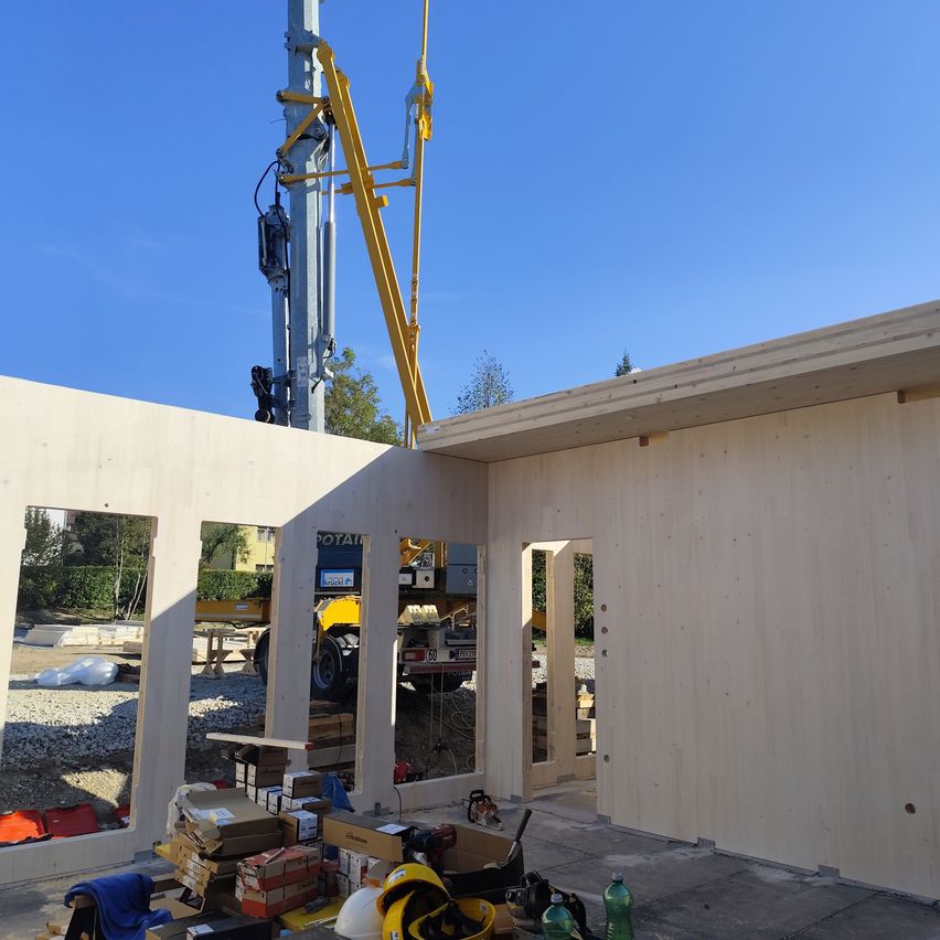 Eine Baustelle mit einem Gebäude im Bau. Ein Kran hebt Materialien.