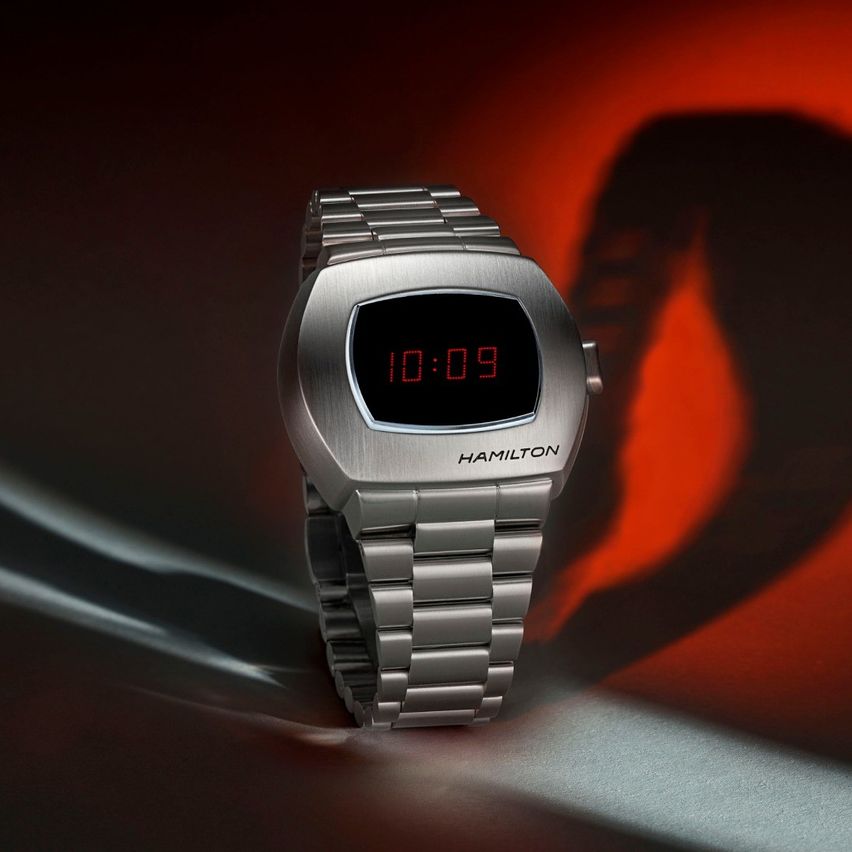 Eine schlanke silberne Hamilton-Armbanduhr mit digitalem Display, das die Zeit 10:09 auf einem leuchtend roten Hintergrund mit Schatteneffekt anzeigt.