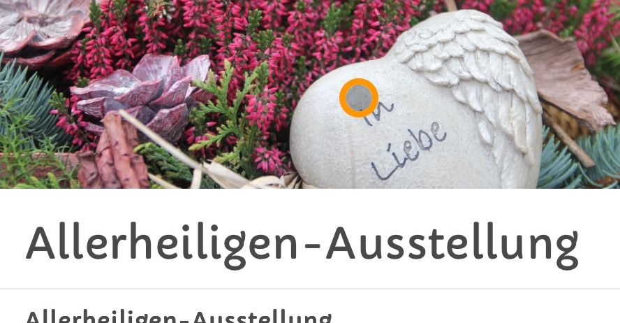 Ein herzförmiger Stein mit Engelsflügeln und dem Wort 'In Liebe' darauf steht zwischen rosa Blumen. Unten steht ein Text 'Allerheiligen-Ausstellung' mit einem Datumsbereich vom 17.10. bis 31.10.2025.