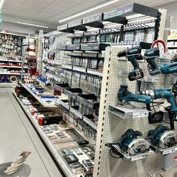 Ein gut organisierter Baumarkt mit verschiedenen Werkzeugen und Geräten zur Schau, einschließlich Bohrmaschinen und Kreissägen.