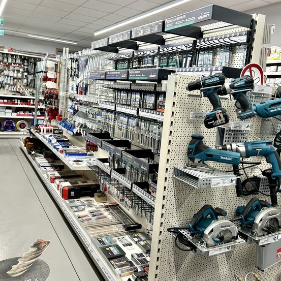 Ein gut organisierter Baumarkt mit verschiedenen Werkzeugen und Geräten zur Schau, einschließlich Bohrmaschinen und Kreissägen.