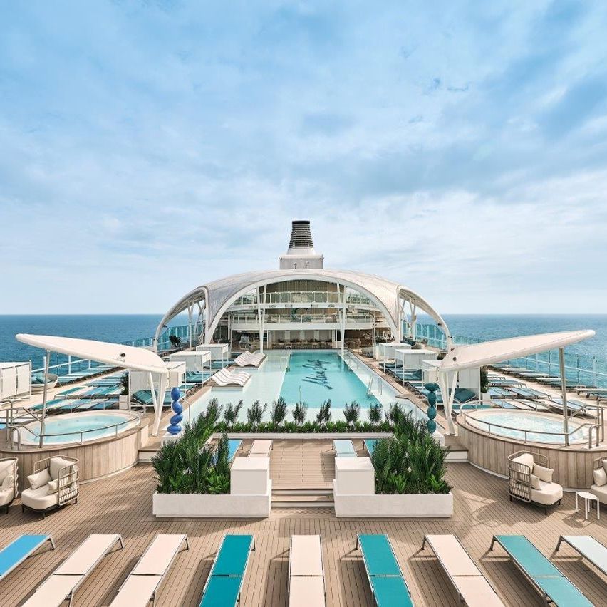 Eine luxuriöse Kreuzfahrtschiff-Deck mit einem großen Pool, Liegestühlen und Blick auf den Ozean.