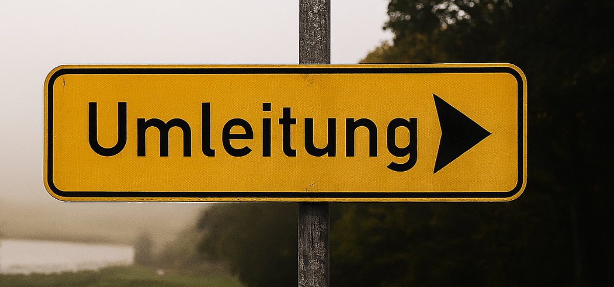 Ein gelbes Schild mit schwarzen Buchstaben und einem Pfeil zeigt nach rechts. Es steht 'Umleitung'. Es ist auf einem Metallpfosten platziert. Dahinter befindet sich eine neblige Landschaft mit einem Grasfeld und Bäumen.