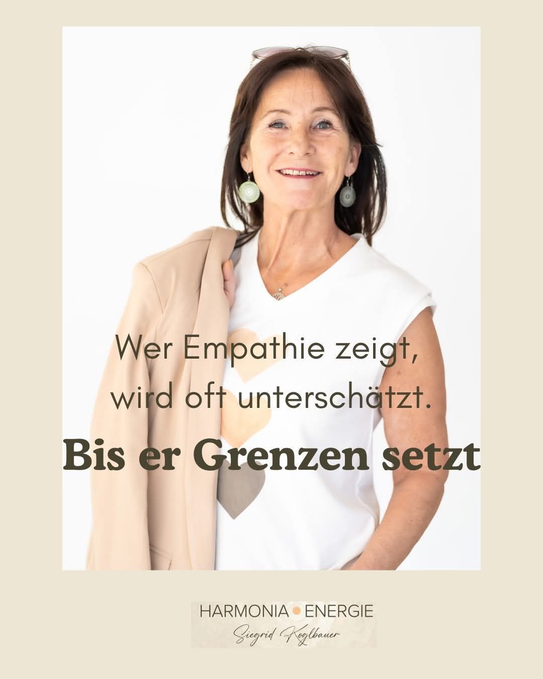 A smiling mature woman with earrings wears a white t-shirt with a heart design. She poses with her arms crossed. The image has a German quote on it.