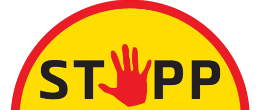 Ein gelbes rundes Schild mit einer roten Hand in der Mitte, das das Wort 'STOP' zeigt. Darunter steht in Schwarz 'der Gewalt an Frauen'. Der Hintergrund ist weiß.