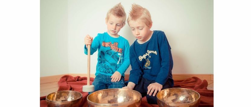 Poster für eine Kindermeditations- und Klangspielstunde in Vorwald/Patergassen. Zwei Jungen sitzen mit Klangschalen auf dem Boden. Kurse für Kinder im Alter von 4-7 und 8-14 Jahren jeden Dienstag. Ort: Turnraum Dr. Hofmeister, Vorwald 7. Kosten: 10 Einheiten für 60 Euro oder einzeln für 10 Euro.