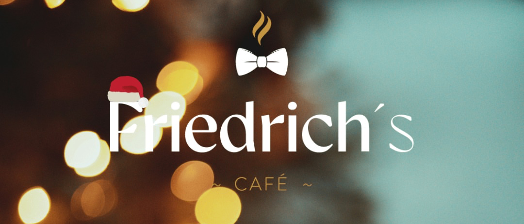 Eine Nahaufnahme einer Kaffeetasse mit dem Wort 'Friedrichs Café' und einem Weihnachtshut im Hintergrund.