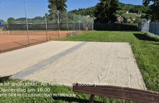 Ein leerer Tennisplatz, umgeben von einem Zaun. Ein sandiger Bereich mit einer Bank. Der Platz ist bis Donnerstag um 16 Uhr geschlossen. Bitte bringen Sie Ihre eigene Ausrüstung mit.