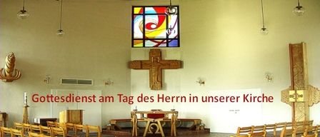 An interior view of a church with a stained glass window, a wooden cross, and a wooden altar. The room is filled with wooden chairs and has a white wall. The words 'Gottesdienst am Tag des Herrn in unserer Kirche' are written on the wall.
