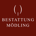 Das Bild zeigt einen roten Hintergrund mit weißem Text. Es steht 'Bestattung Modling', was darauf hinweist, dass es sich wahrscheinlich um das Logo eines Unternehmens oder einer Dienstleistung im Zusammenhang mit Bestattungsarrangements in Modling handelt.