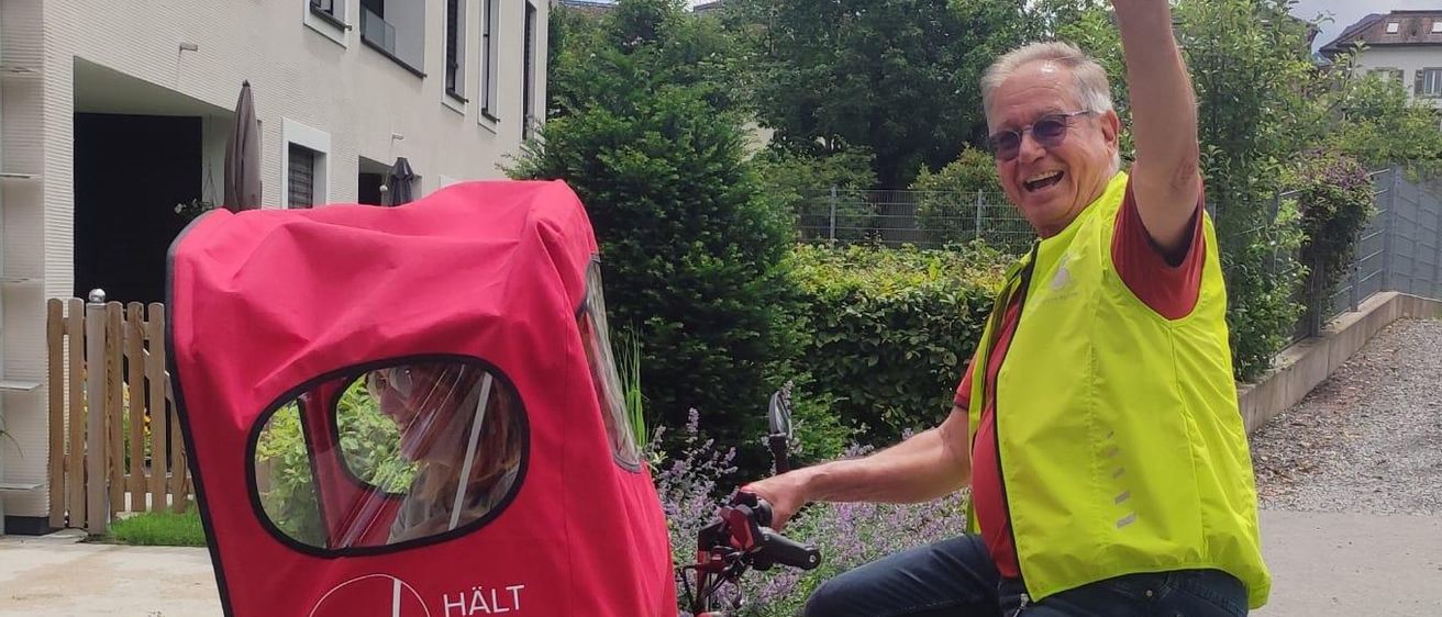 Bild enthält, Tricycle, Vehicle, E-scooter, Machine, Wheel, Street, Urban, Person, Glasses, Photobombing