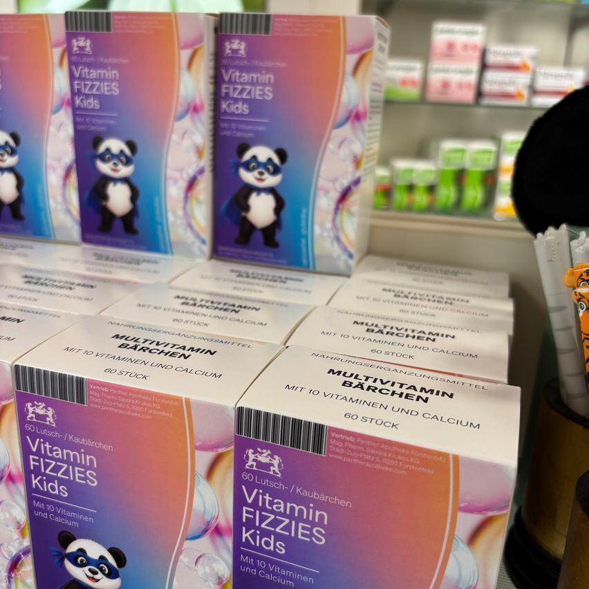 A display of Vitamin Fizzies Kids boxes with a panda mascot, arranged on a shelf in a store.